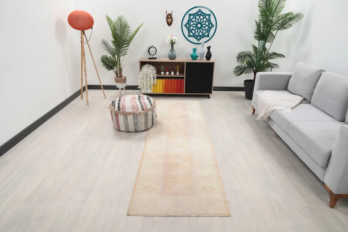 Runner rug in a living room setting with a sofa and plants, viewed from an angle
