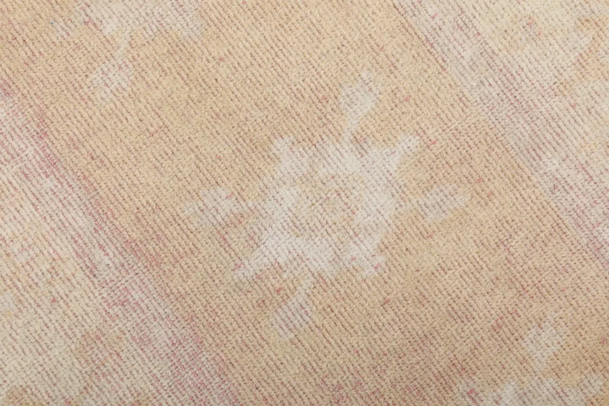 Close-up of a faded geometric motif in the rug's pile