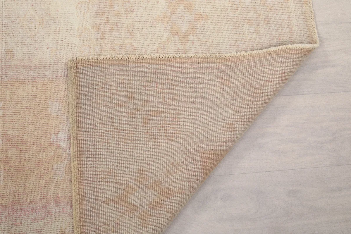 Folded corner of the rug, showing the back and pile structure
