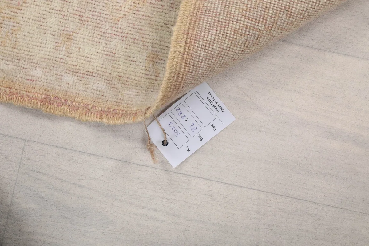 Close-up of the rug's label with size information, attached to the corner