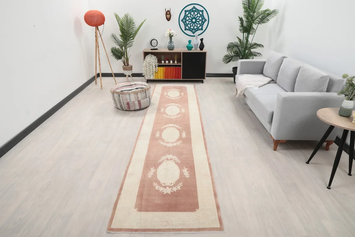 Long view of the rose and ivory runner rug in a modern living room setting with a light gray couch