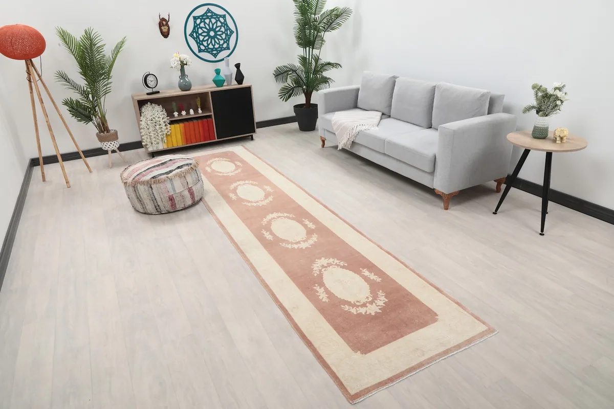 Overhead angle of the rose and ivory runner rug in a contemporary room setup with wooden furniture