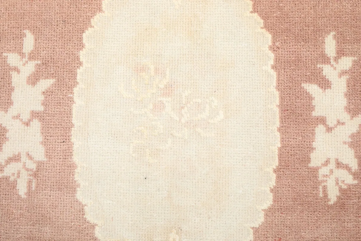 Extreme close-up of the central ivory medallion, highlighting the intricate floral motifs within
