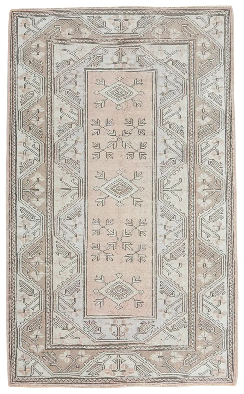 Full top view of the vintage Anatolian area rug in rose and beige with geometric patterns