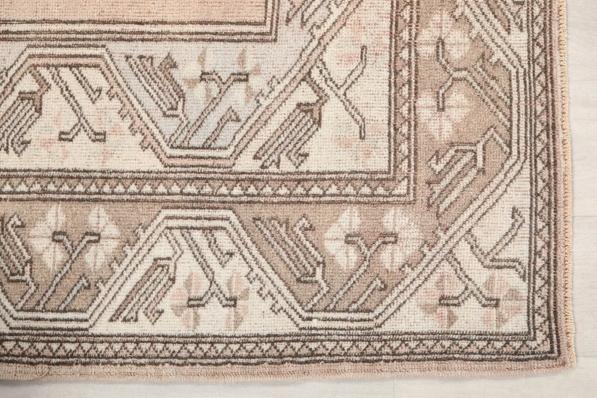 Detailed view of the corner motif and geometric patterns on the rug's border