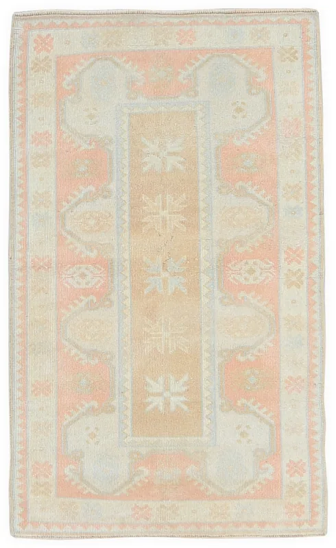Top view of a 2'7" x 4'4" vintage Anatolian rug with rose, tan, and blue geometric patterns