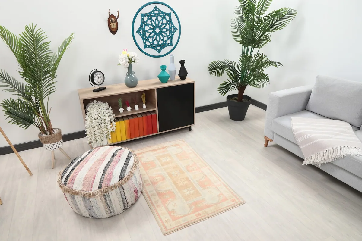 Overhead view of the rose and tan geometric rug in a living space with plants and furniture