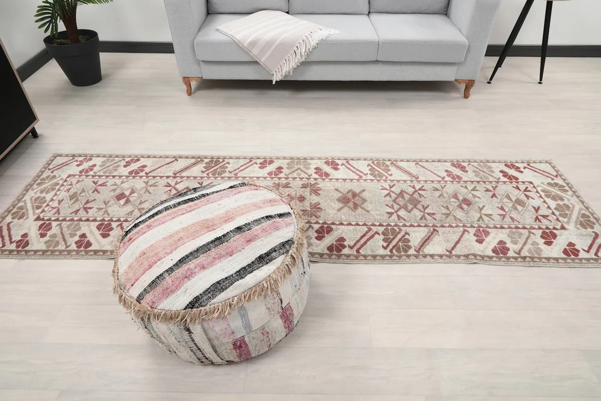Full length view of the runner rug in a room with a sofa and ottoman