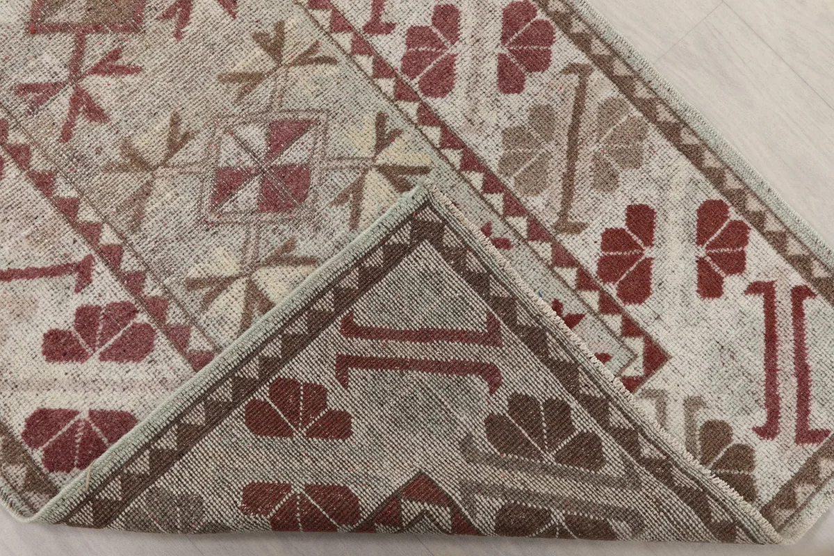 Folded corner of the runner rug showing the reverse side and pile texture