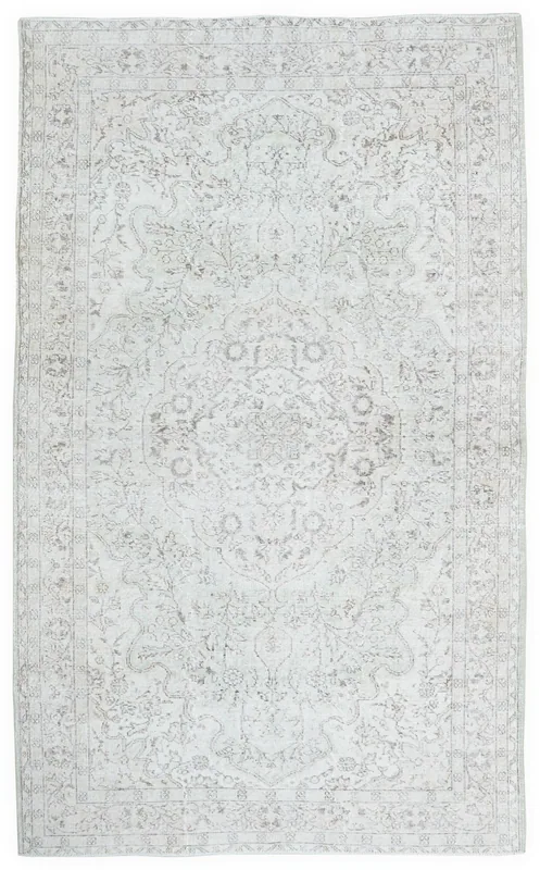 Full overhead view of the vintage Anatolian ivory medallion floral area rug on a white background.