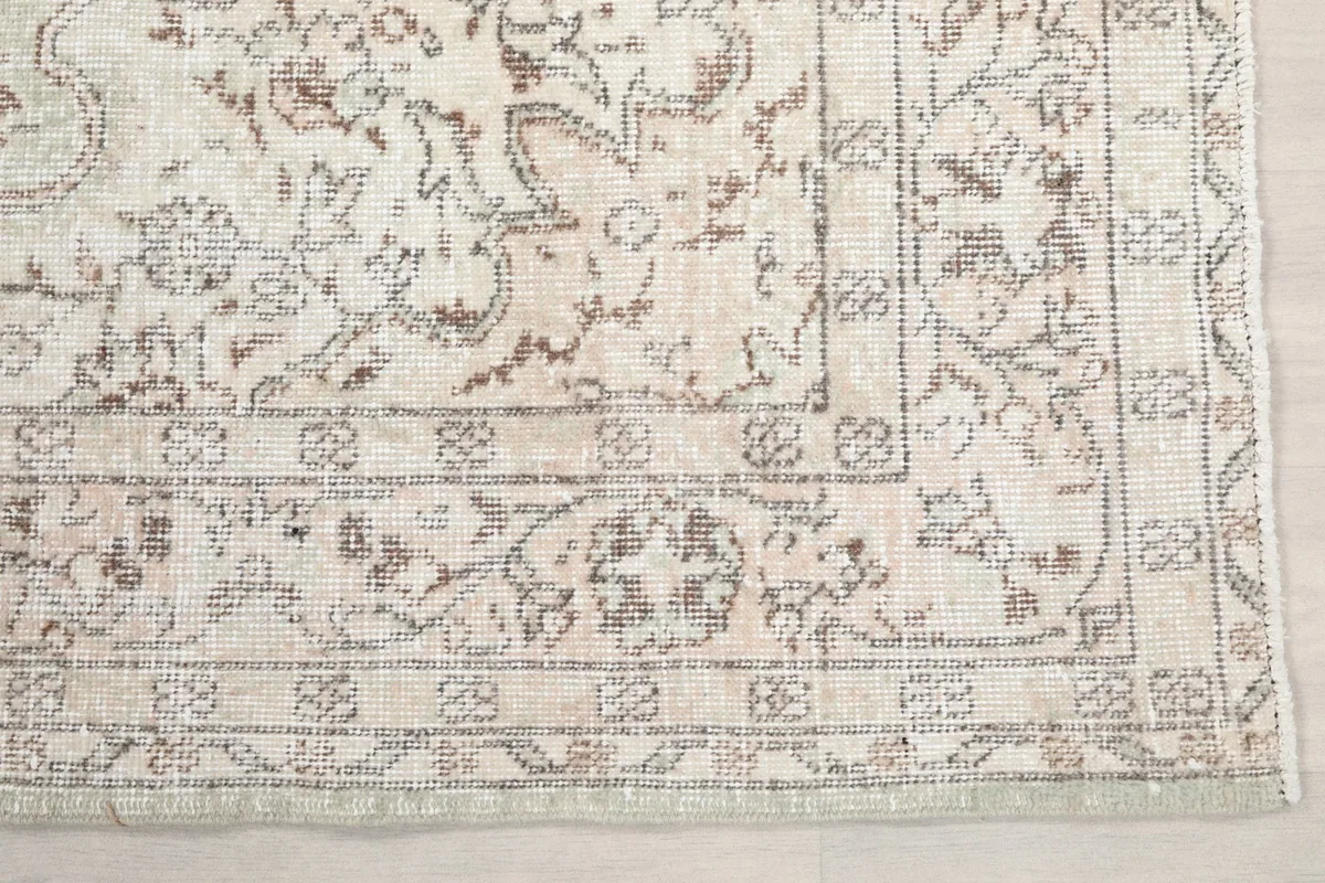 Detail of the rug's border and corner, showing the intricate geometric and floral design.