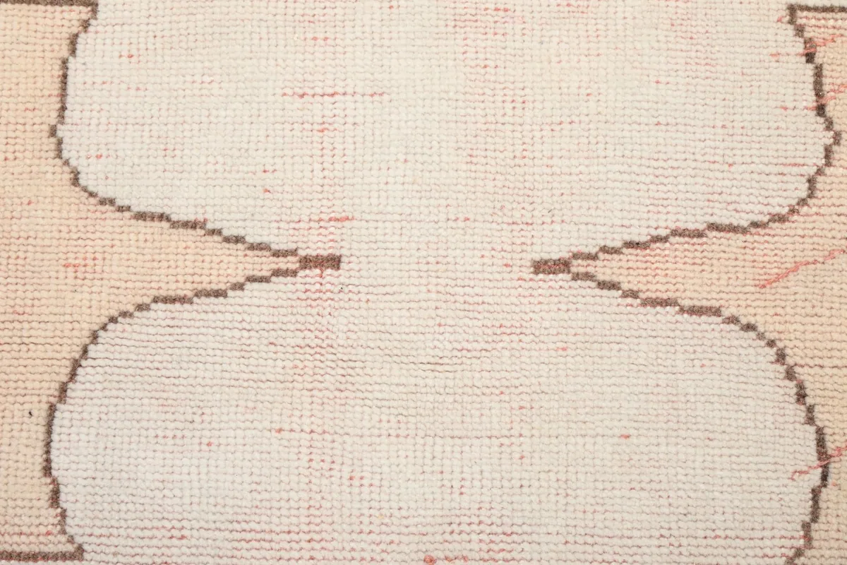 Close-up of the low wool pile texture and hand-knotted weave of the rug