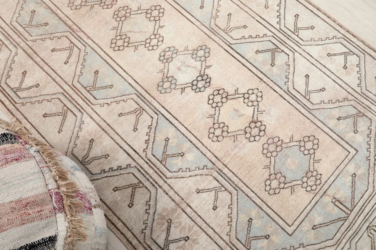 Angled shot showcasing the central geometric motifs and the surrounding beige field.