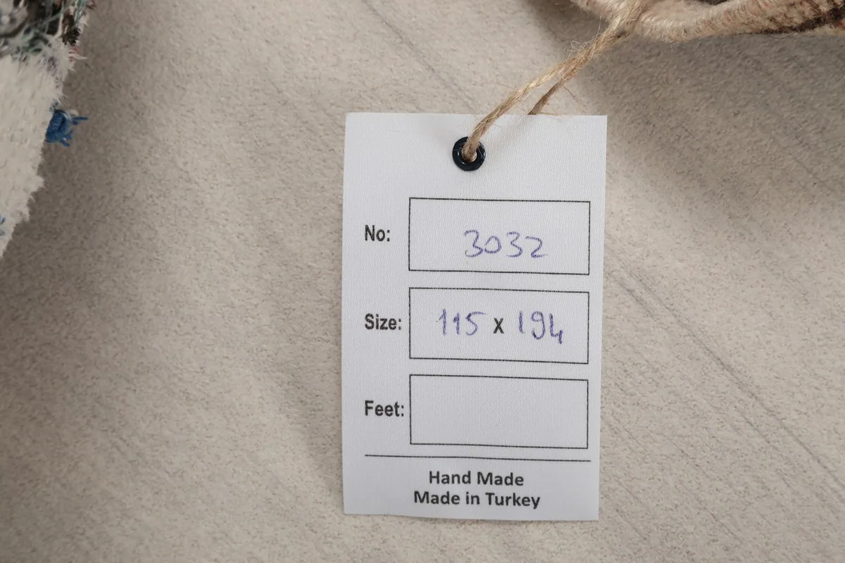 Product tag indicating the rug's number and size in centimeters, confirming handmade origin.