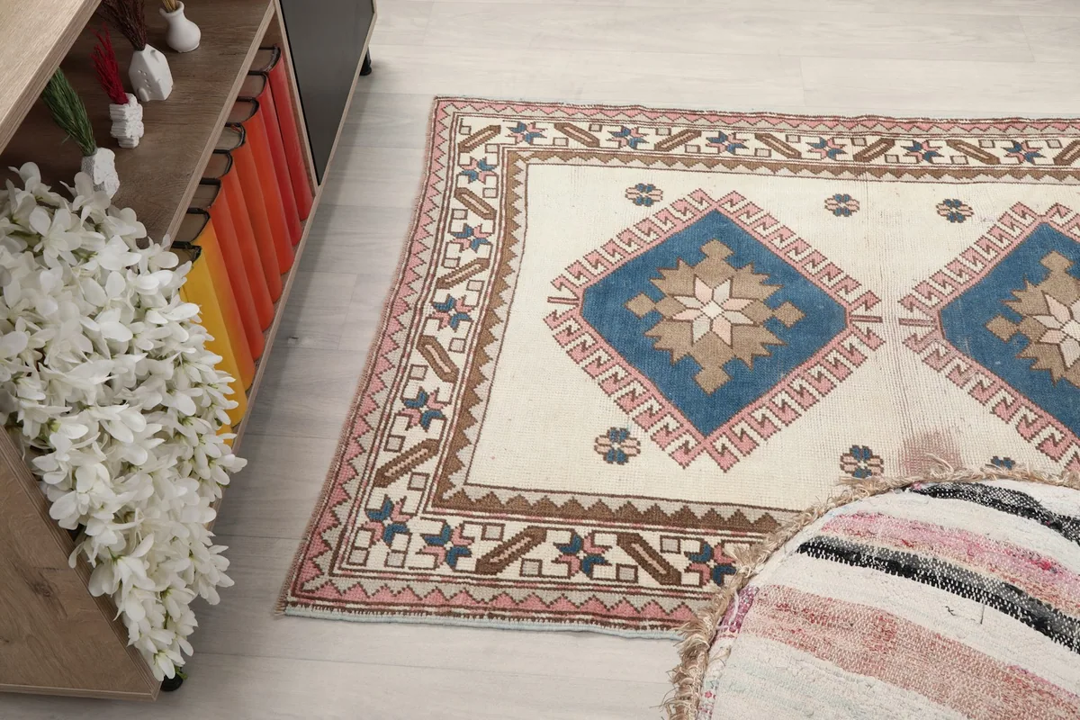 Angled view of the rug's side, showing the texture and colors next to a pouf