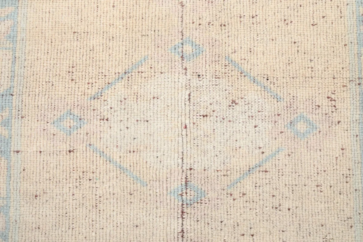 Close-up of the central geometric motif within the rug's field, highlighting the wool pile.