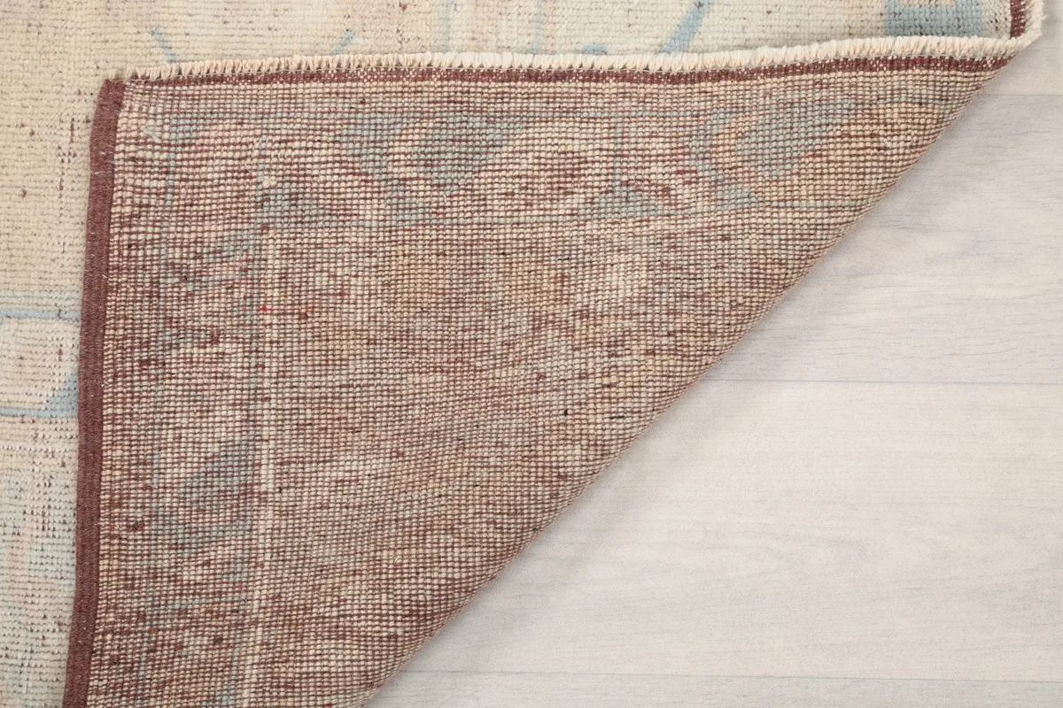 Angled view of the rug's back, revealing the tight weave of the cotton foundation.