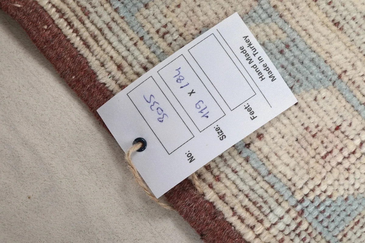 Close-up of the product tag attached to the rug, displaying its dimensions and origin.