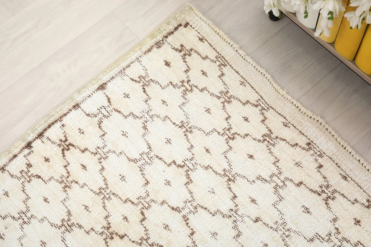 Corner view of the rug, showing the geometric pattern and the edge finishing