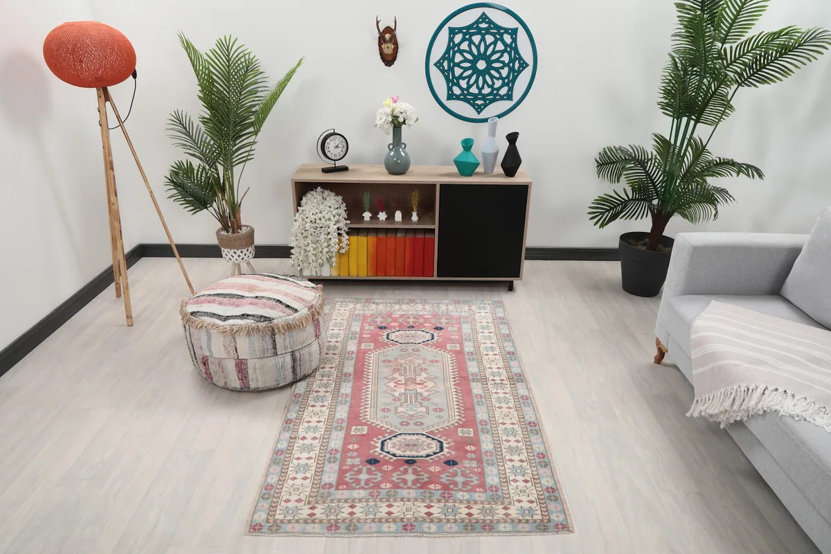Vintage Anatolian rug displayed in a modern living space with a sofa and ottoman