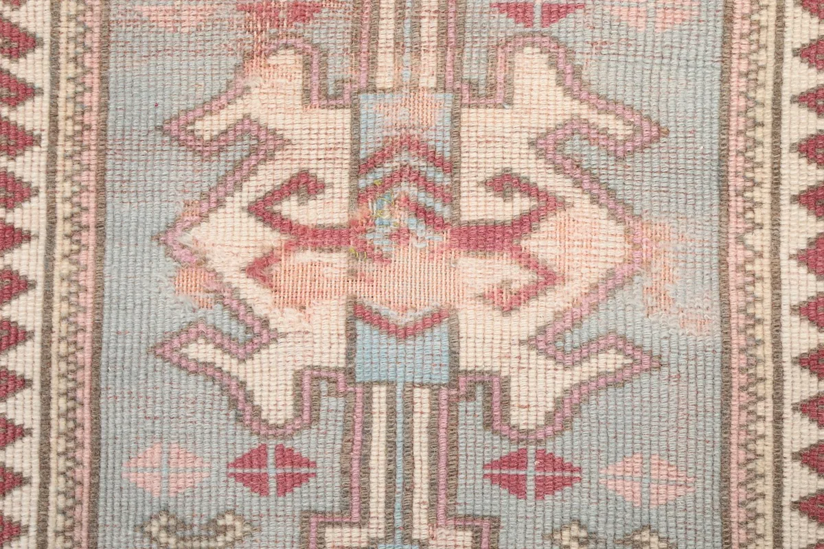Close-up of the intricate geometric pattern within the central medallion of the rug