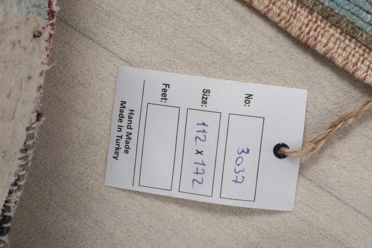 Close-up of the product tag attached to the rug, showing measurements and origin