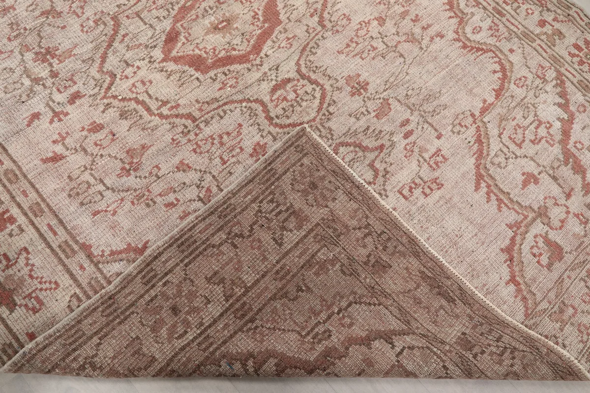 Folded corner of the rug, revealing the reverse side with visible knotting and cotton foundation