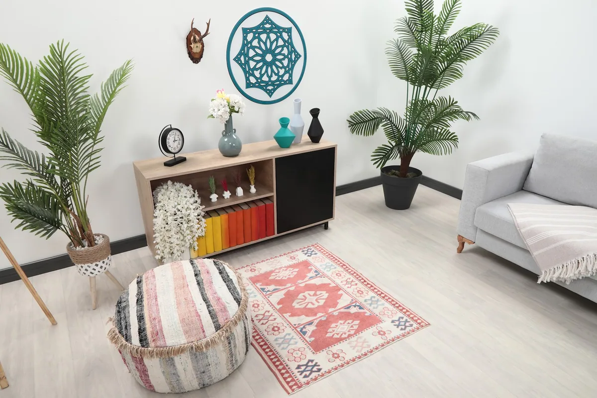 Overhead view of the rug placed in a room setting next to a striped pouf