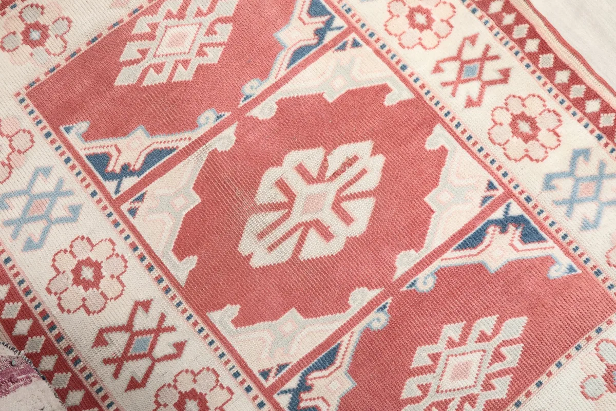 Angled detail of the central red field and surrounding ivory border patterns
