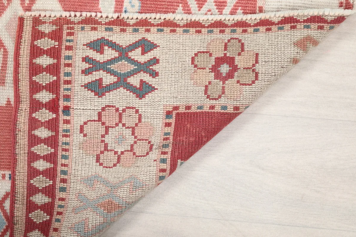 Angled view of the back of the rug, revealing the knotting and foundation