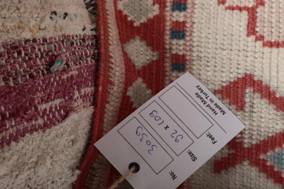 Detail of the rug with a size tag showing 92 x 109 cm measurements