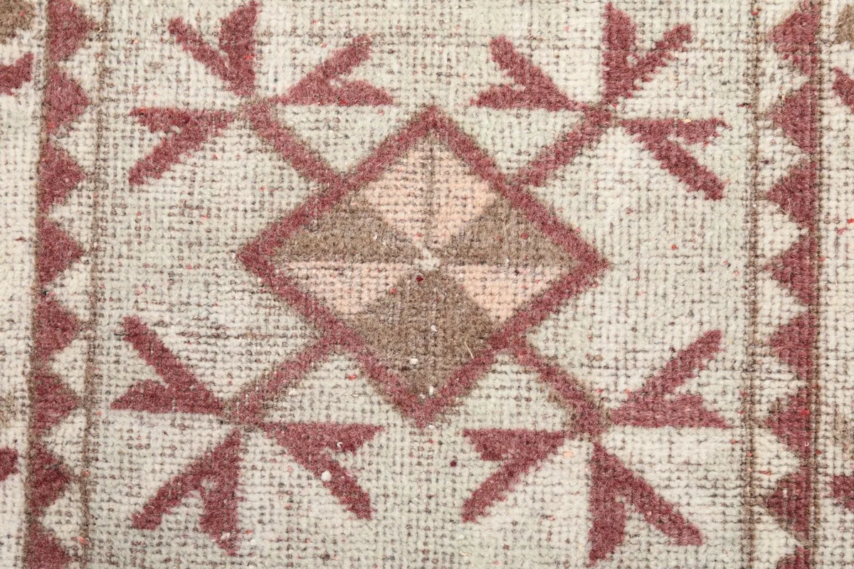 Macro shot of a central rust and cream geometric motif with surrounding details