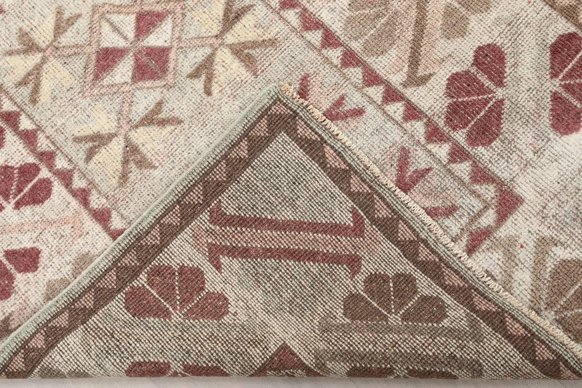 Folded corner of the rug revealing the hand-knotted cotton foundation
