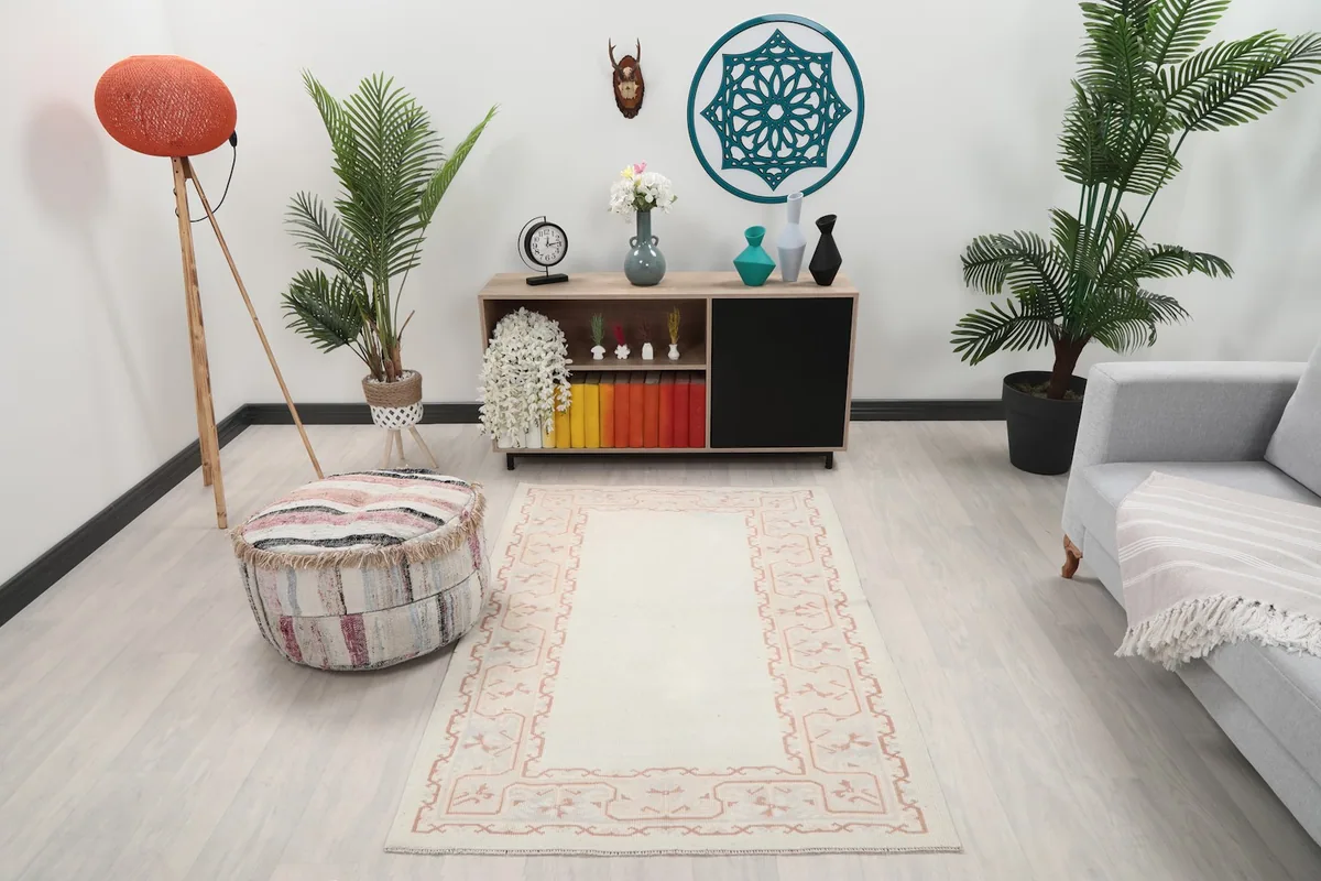 Ivory and rose vintage rug styled in a living room setting with modern furniture
