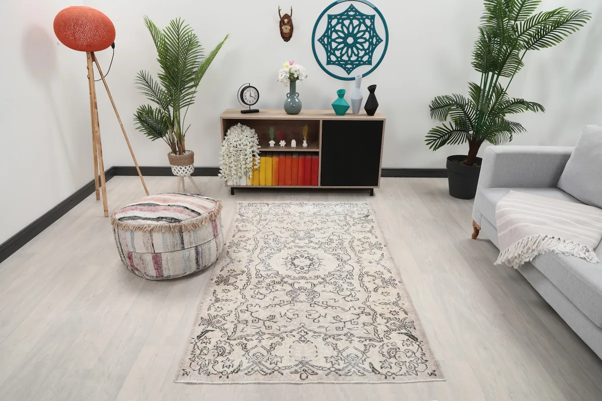 Vintage Anatolian rug in a room setting with light gray sofa and wooden cabinet