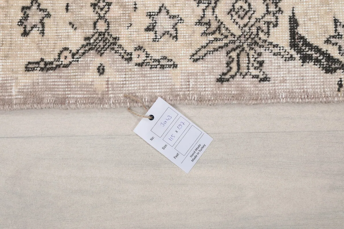 Product tag on the rug showing dimensions 115 x 197 cm