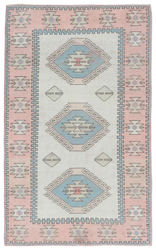 Full overhead view of the 4'0" x 6'9" vintage Anatolian rug with pink border and ivory field