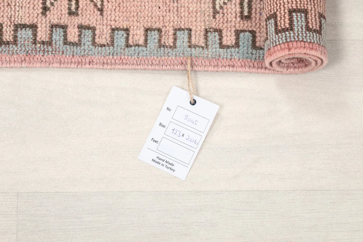 Rolled edge of the rug with a product tag, indicating its origin and material