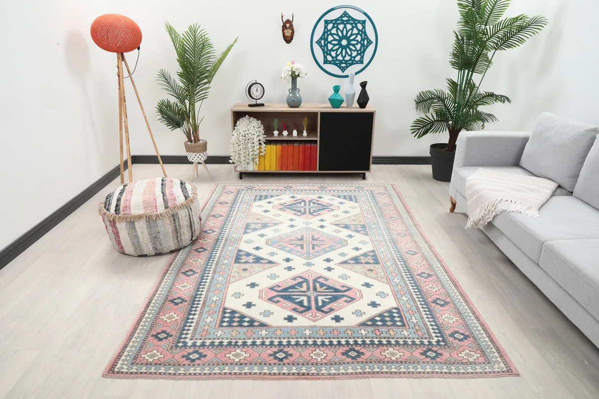 Area rug with ivory, pink, and blue geometric design displayed in a modern living room setting