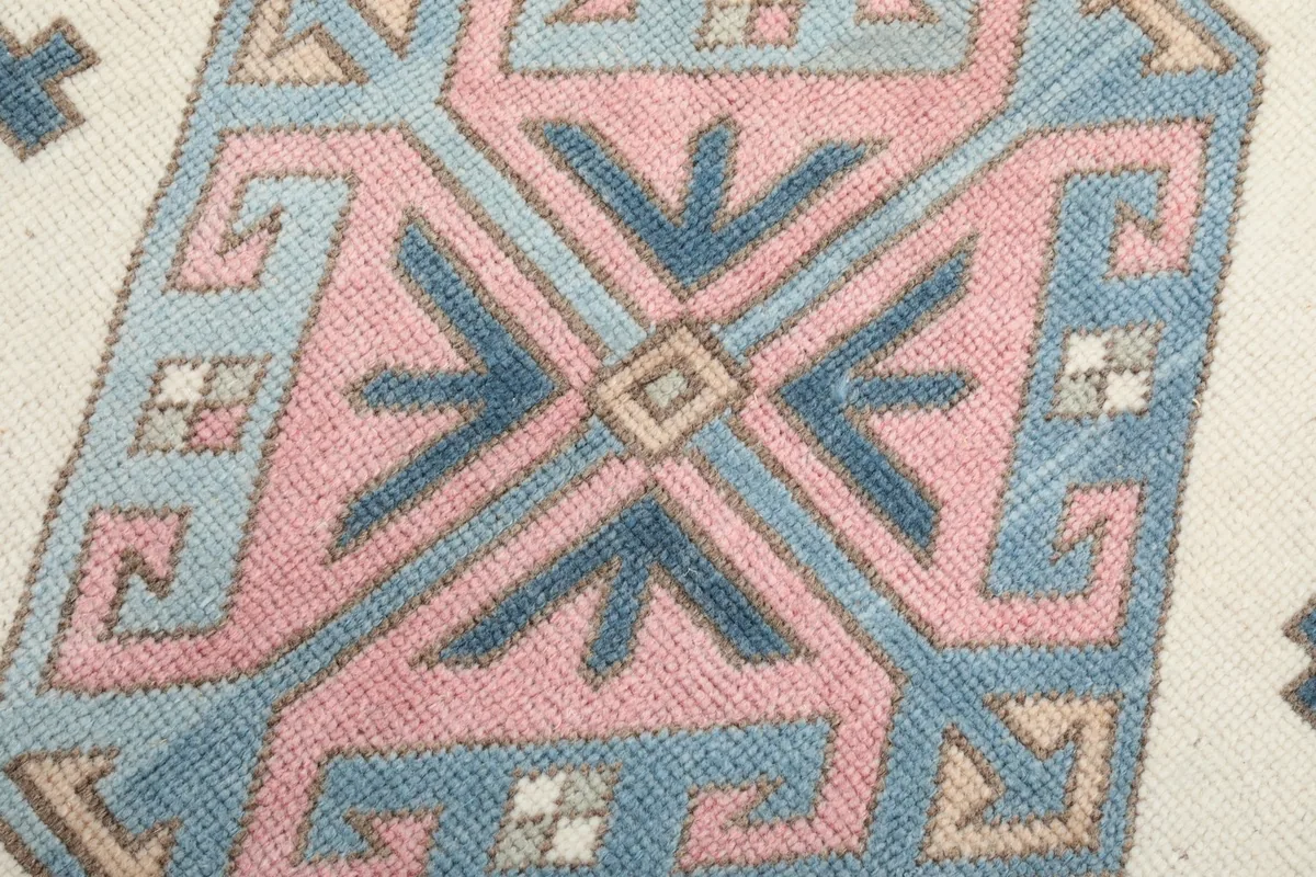 Detailed view of a central geometric medallion with pink, blue, and navy hues
