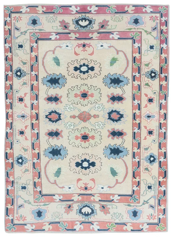 Full top view of the 5'2" x 7'4" ivory, rose, and blue vintage Anatolian rug on a white background.