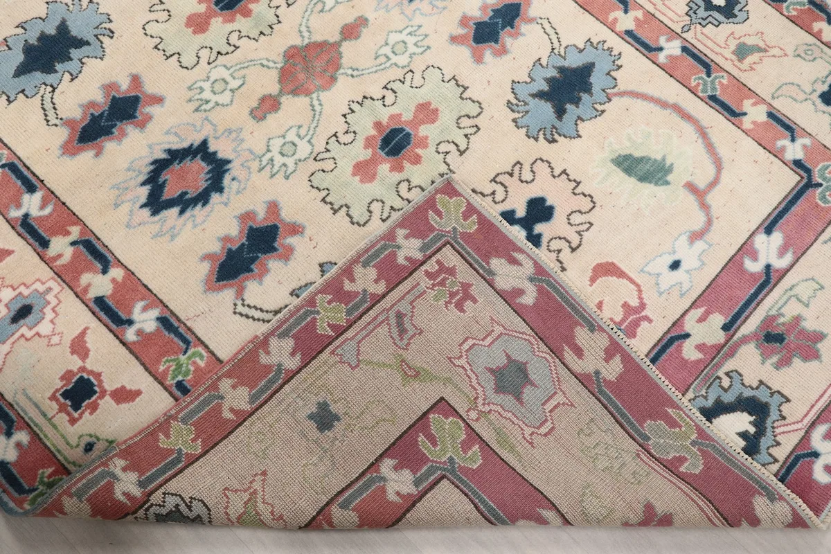View of the rug's corner folded back, revealing the reverse side of the hand-knotted wool pile.