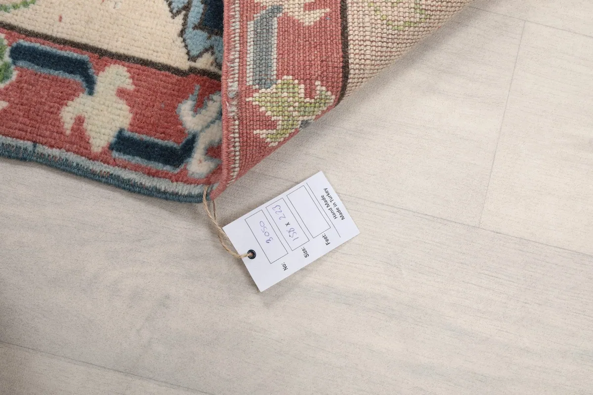 Close-up of the product tag attached to the rug, displaying its size and material information.