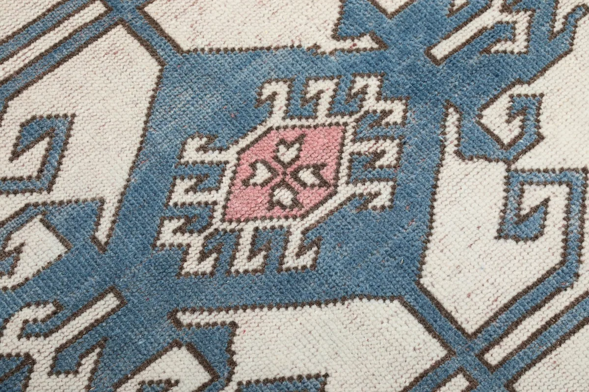 Close-up detail of the intricate blue and pink geometric patterns within the central medallion