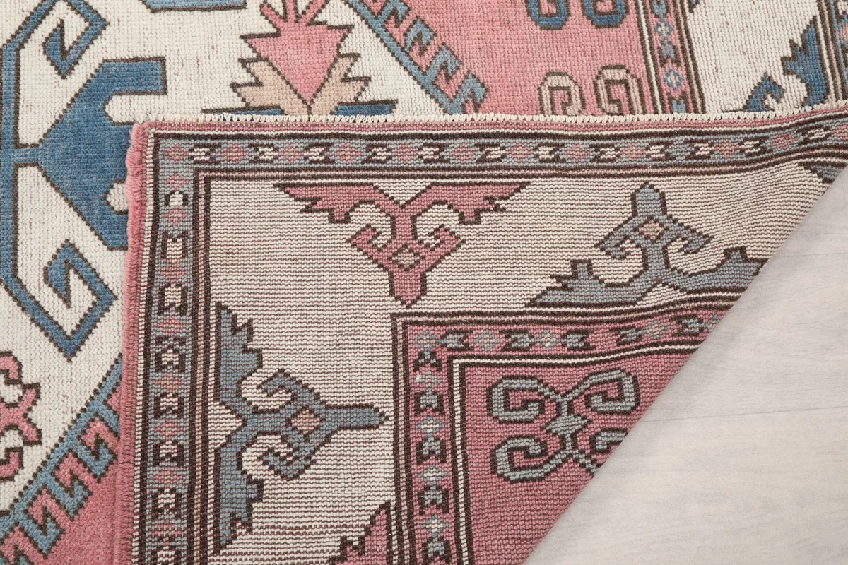 Close-up of the rug's cotton foundation and hand-knotted construction from the back