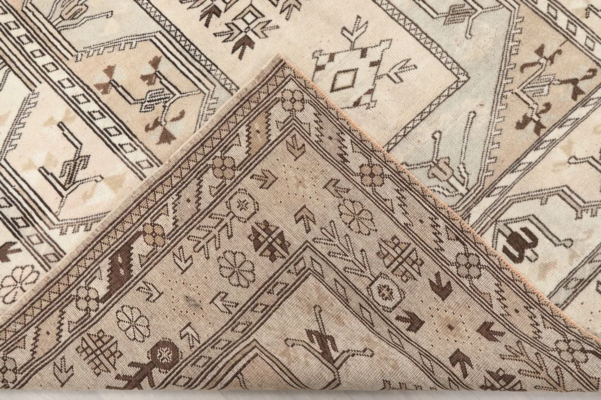 Folded corner of the rug, revealing the wool pile and cotton foundation