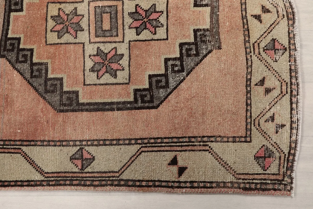 Detail of the geometric border and a corner medallion on the vintage rose runner rug.