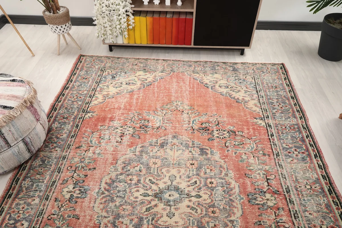 View of the vintage rug from another angle in the room, highlighting its distressed appearance
