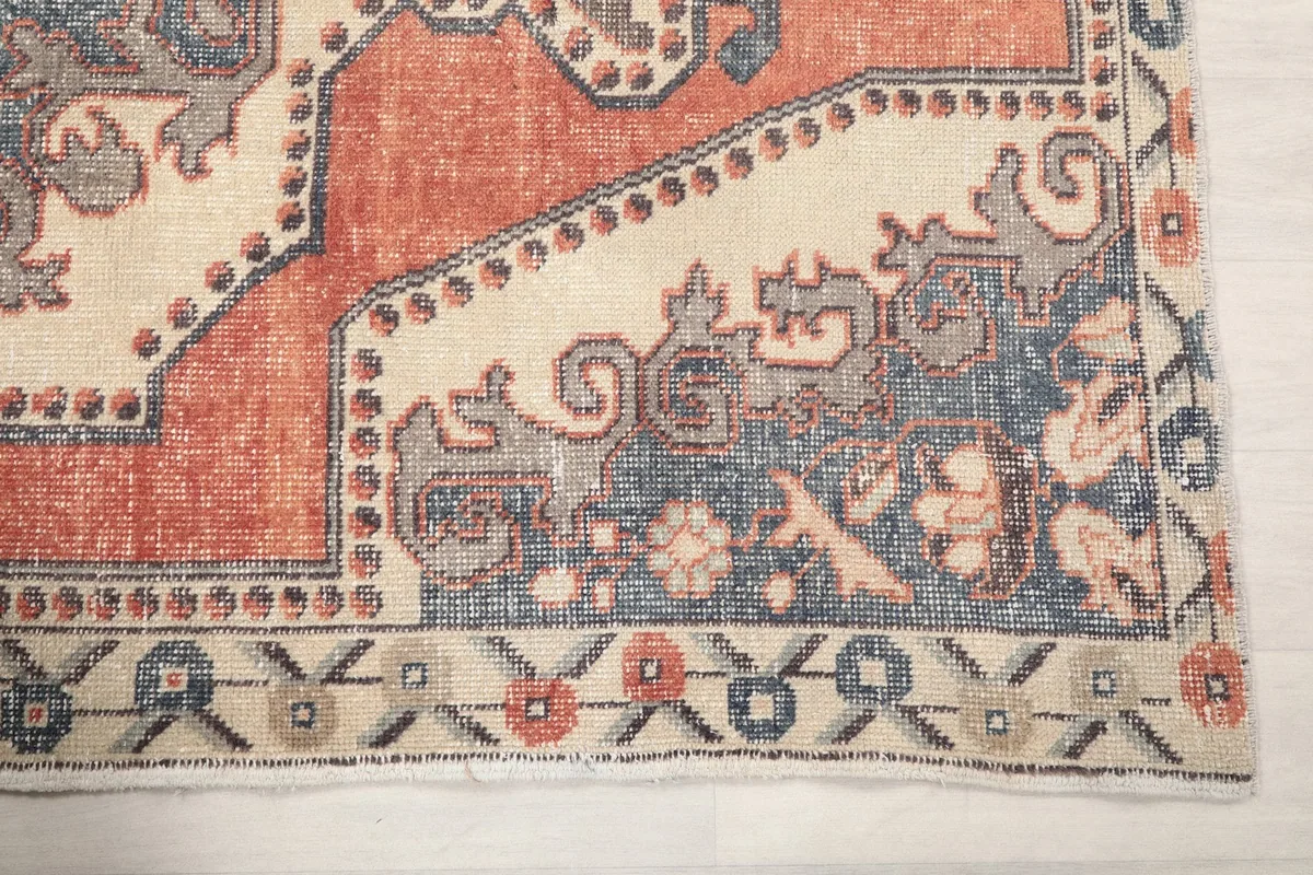 Detailed view of the rug's corner motif and border in blue and beige