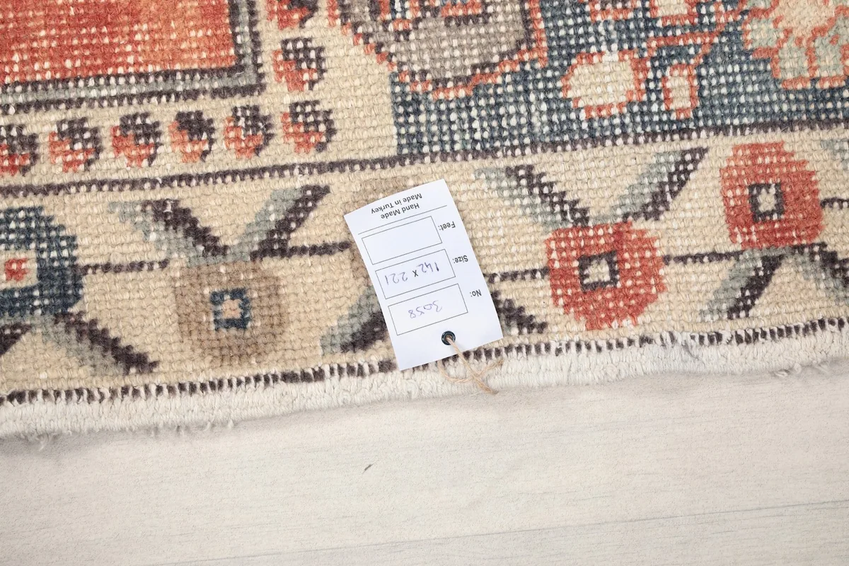 Close-up of the rug's fringe and a tag showing the dimensions
